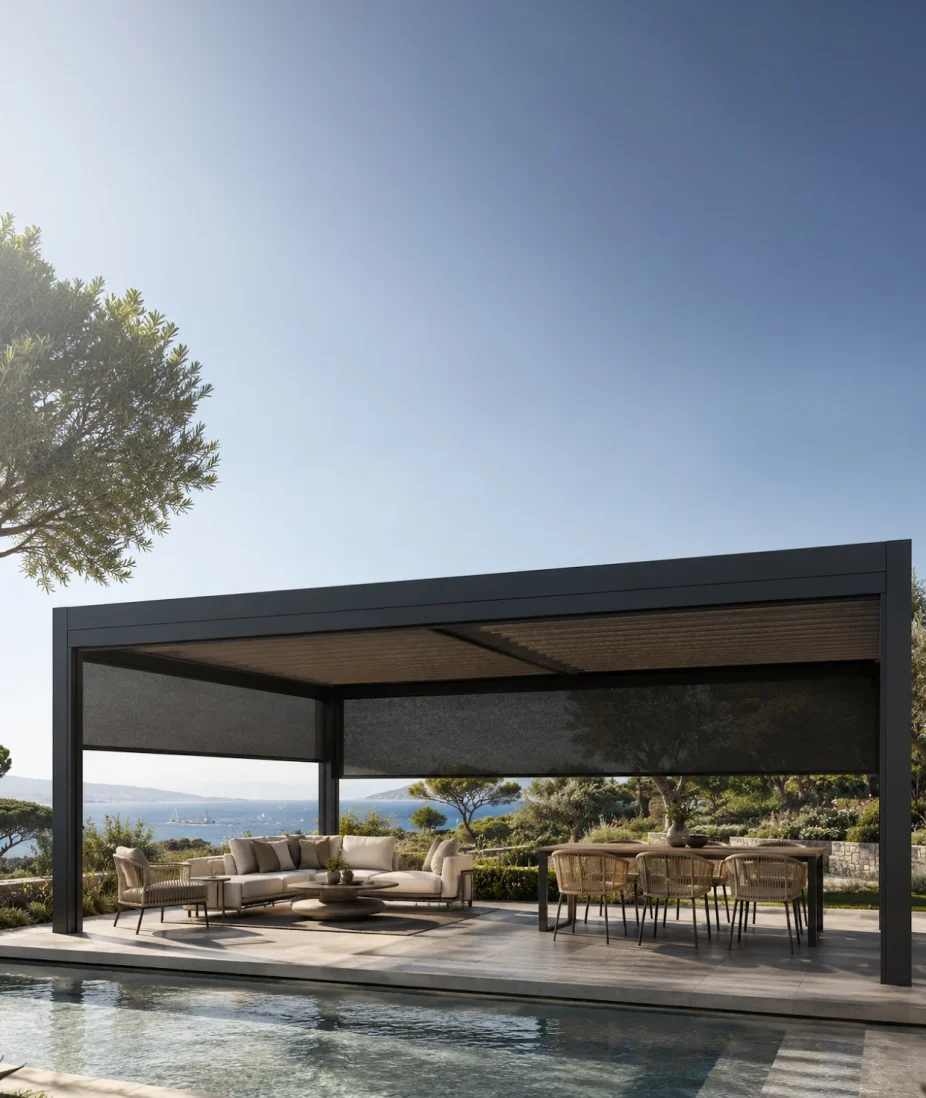 Pergola bioclimatique équipée de stores screen tissés anthracite, avec salon et table de jardin face à la mer